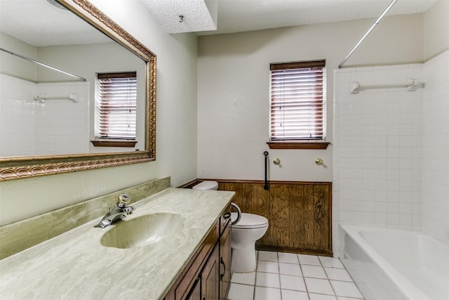 full bathroom featuring tiled shower / bath combo, toilet, a textured ceiling, tile patterned floors, and vanity