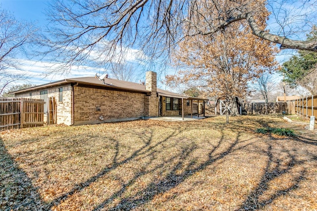 rear view of property featuring a yard and a patio area