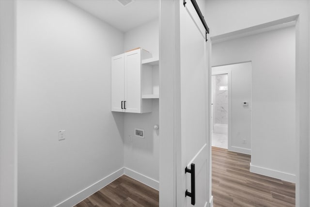 laundry room with cabinets, hardwood / wood-style floors, washer hookup, and a barn door