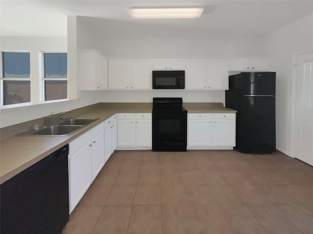 kitchen featuring white cabinetry, sink, black appliances, and light tile patterned flooring