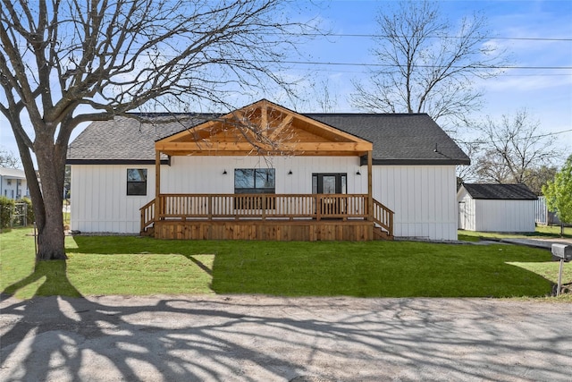 view of front facade featuring a storage unit, a deck, and a front yard