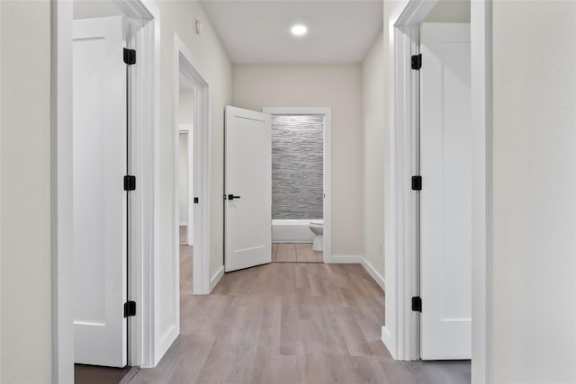 corridor with light hardwood / wood-style floors