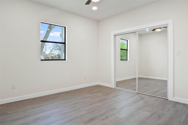 unfurnished bedroom with a closet, ceiling fan, and wood-type flooring