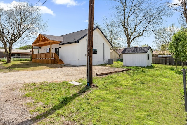 view of yard with central AC and a storage shed