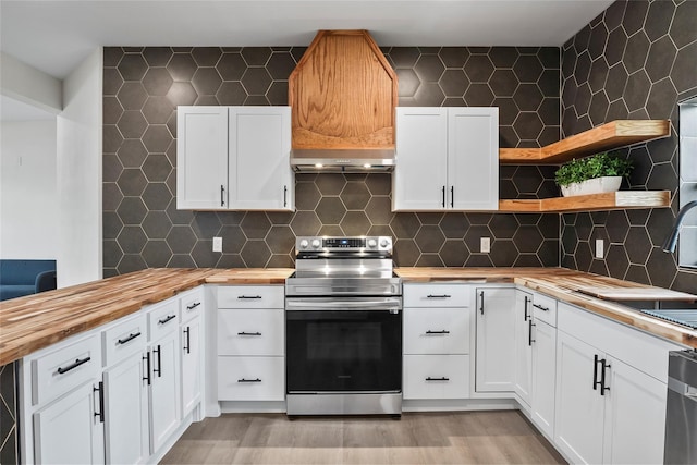 kitchen with stainless steel electric range oven, white cabinetry, butcher block counters, and decorative backsplash