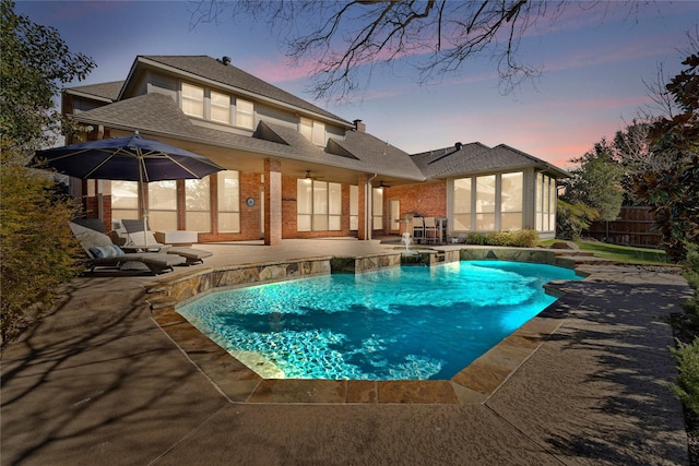 pool at dusk featuring a patio, fence, and a fenced in pool