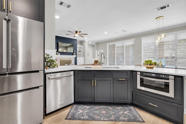 kitchen with stainless steel appliances, light countertops, a sink, and visible vents