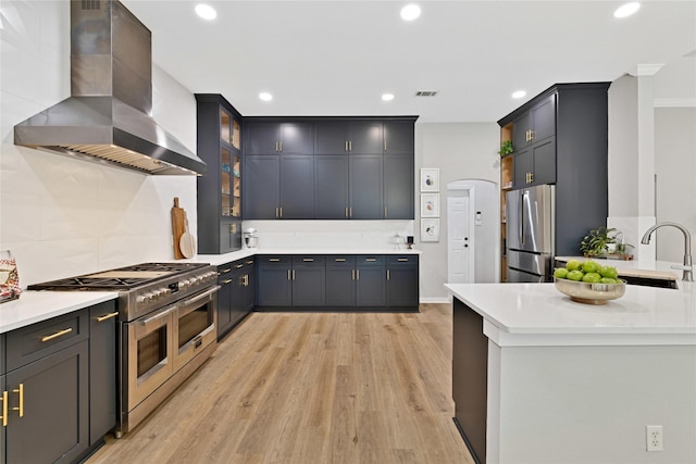 kitchen featuring range hood, visible vents, stainless steel appliances, and light countertops