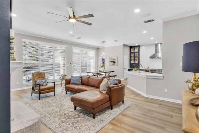 living room featuring light wood-style floors, baseboards, and ornamental molding