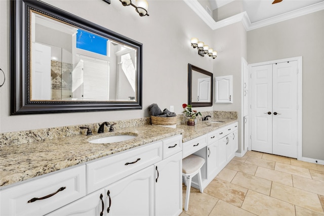 bathroom with baseboards, double vanity, a sink, and crown molding