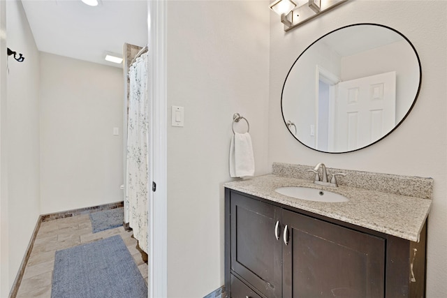 full bath featuring vanity and baseboards