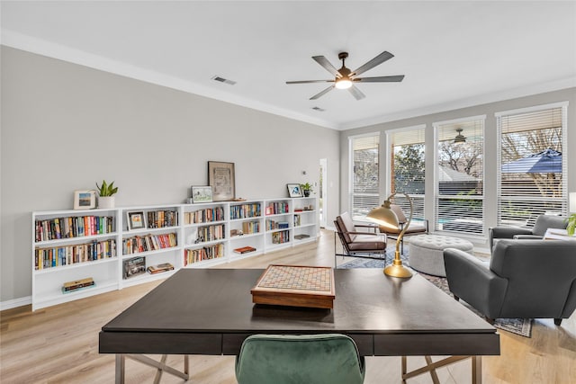 home office with visible vents, baseboards, a ceiling fan, light wood finished floors, and crown molding