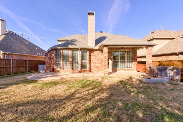 back of property with a patio area and a yard