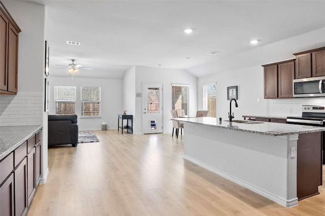 kitchen with a wealth of natural light, visible vents, appliances with stainless steel finishes, a sink, and light wood-type flooring