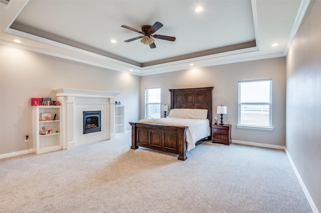 carpeted bedroom featuring a raised ceiling, multiple windows, and crown molding