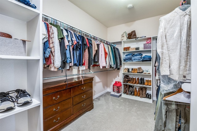 walk in closet featuring light colored carpet