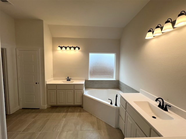 bathroom with tile patterned flooring, vanity, and a washtub