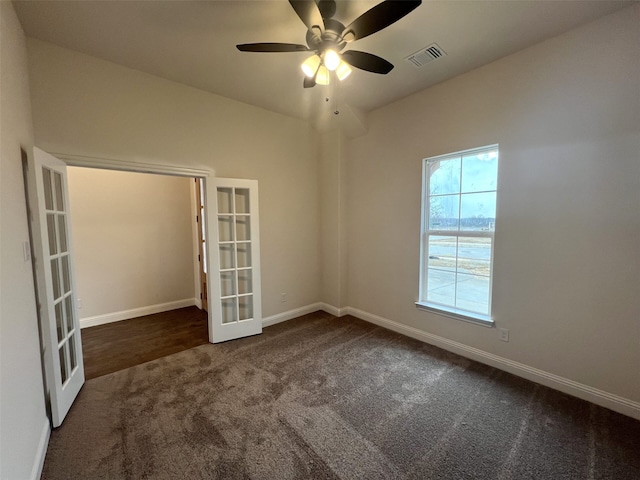 unfurnished room with dark carpet, ceiling fan, and french doors