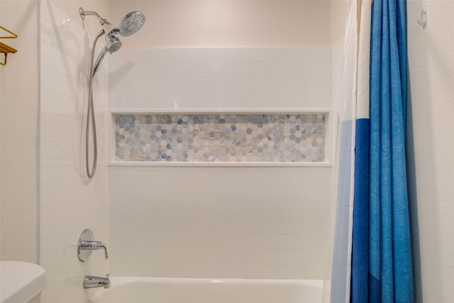 bathroom featuring toilet and shower / bath combination with curtain