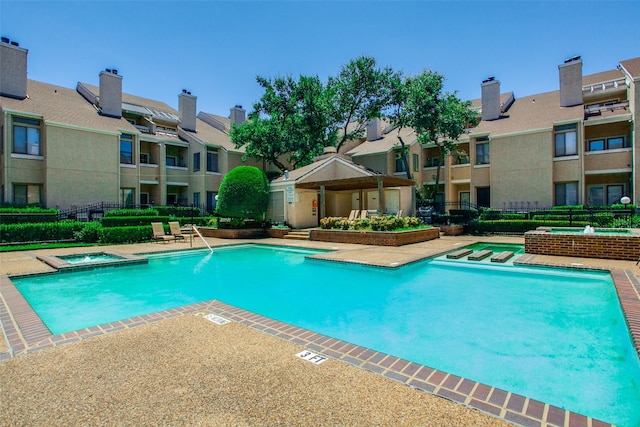 view of swimming pool with a patio area and a hot tub