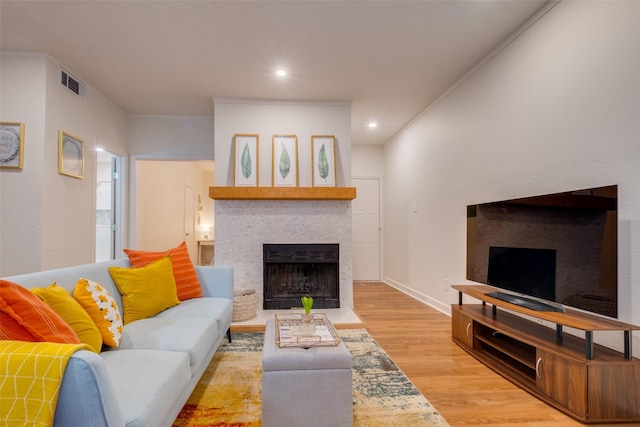 living room with light wood-type flooring and crown molding