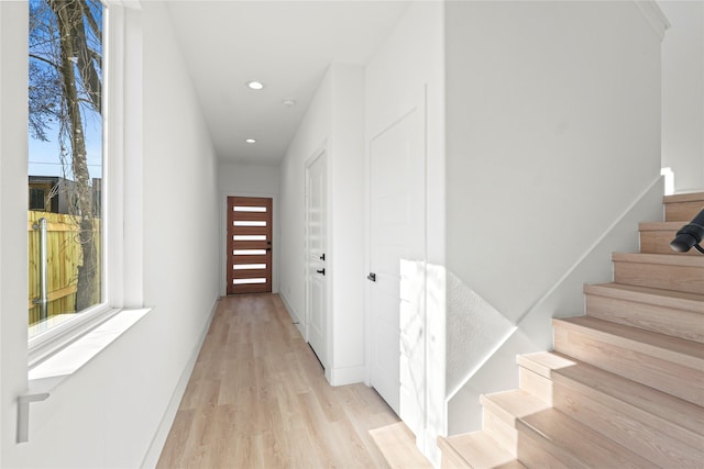 hall with light hardwood / wood-style floors and a wealth of natural light