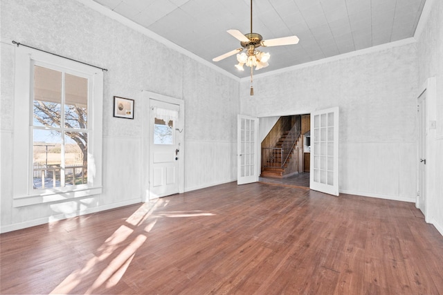 unfurnished living room featuring ceiling fan, ornamental molding, and dark wood-type flooring