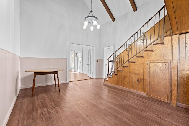 entryway with high vaulted ceiling, beamed ceiling, a notable chandelier, and wood-type flooring