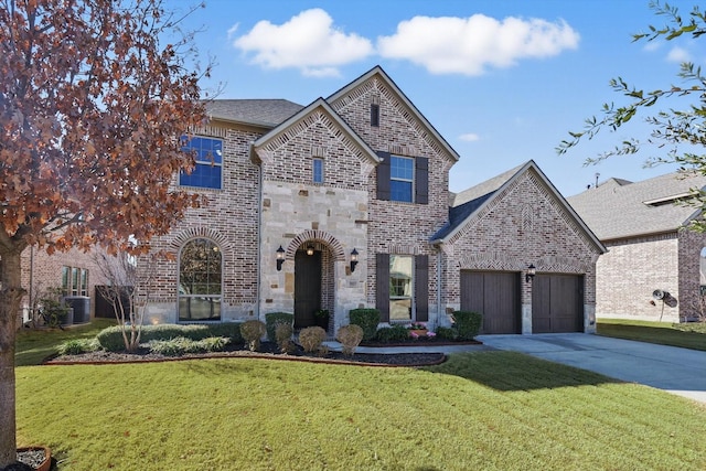 907 Highpoint Way, Roanoke, TX 76262 - french country style house featuring concrete driveway, a front yard, a garage, and brick siding