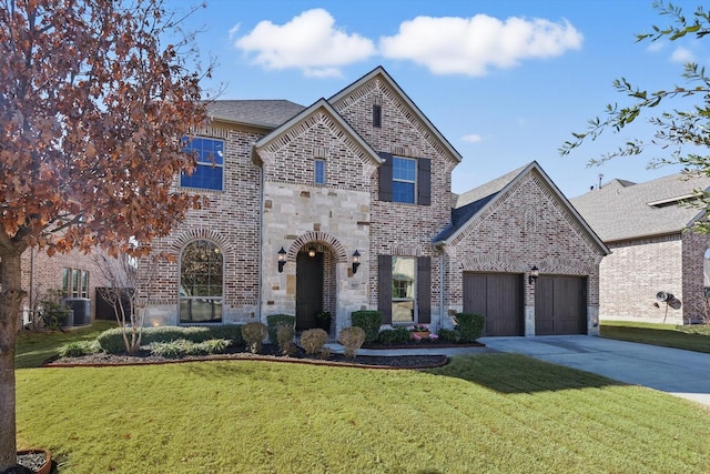 french country home featuring a garage, brick siding, stone siding, driveway, and a front yard