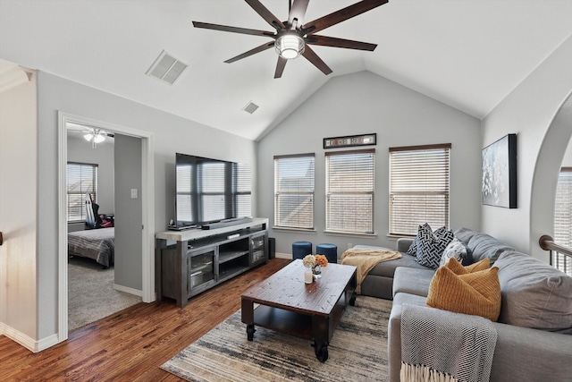 living area featuring vaulted ceiling, ceiling fan, dark wood-type flooring, and visible vents