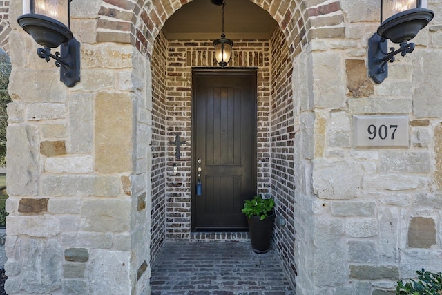 property entrance featuring stone siding and brick siding