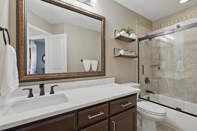 bathroom with toilet, shower / bath combination with glass door, and vanity