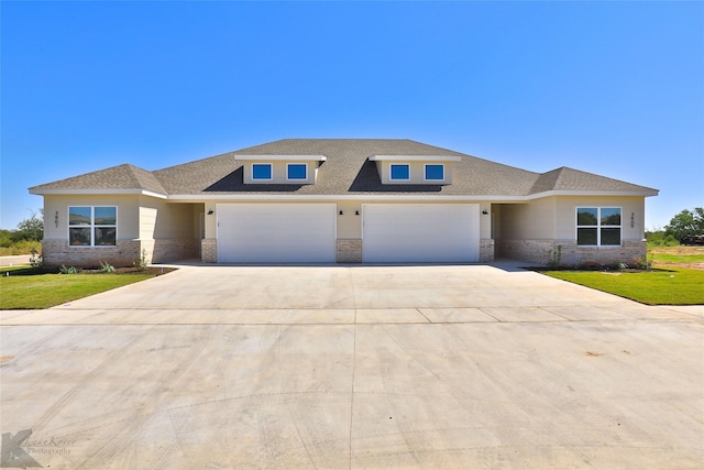 prairie-style home featuring a front lawn and a garage