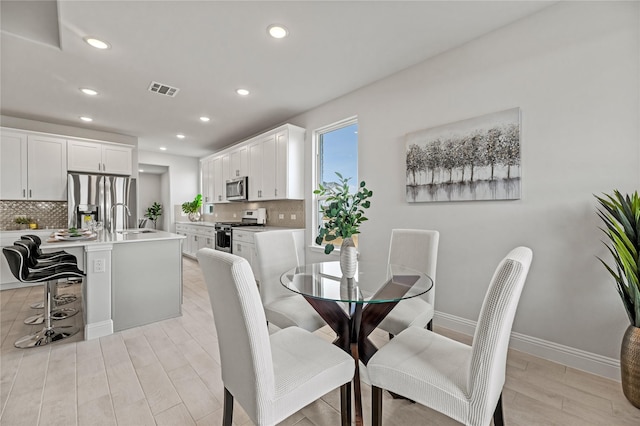 dining space with recessed lighting, baseboards, visible vents, and light wood-style flooring