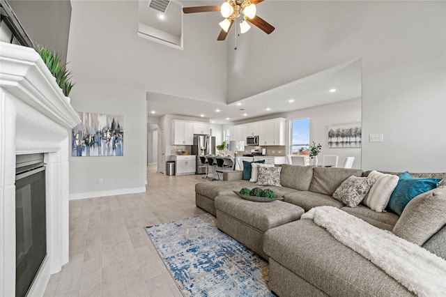 living room with ceiling fan, recessed lighting, baseboards, light wood-type flooring, and visible vents