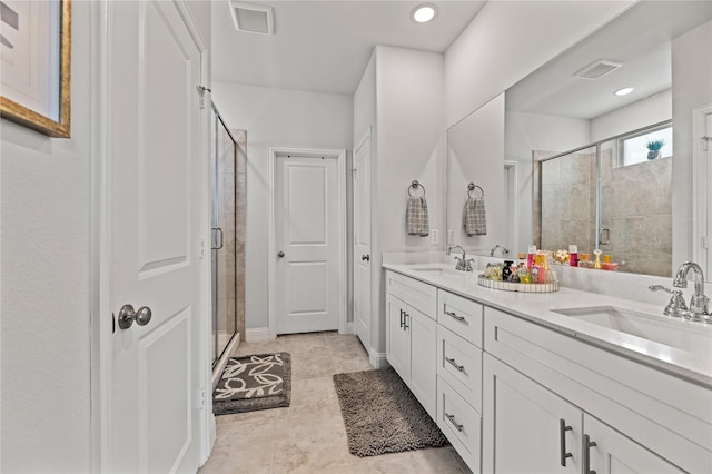 full bath with visible vents, a shower stall, and a sink
