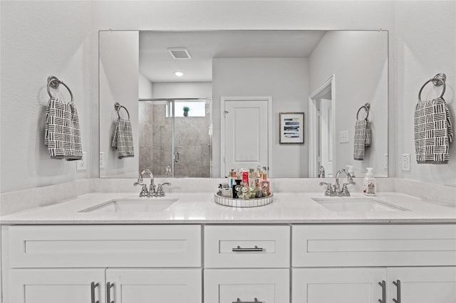 full bathroom featuring a sink, a shower stall, and double vanity