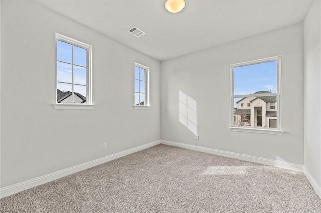 carpeted spare room with visible vents and baseboards