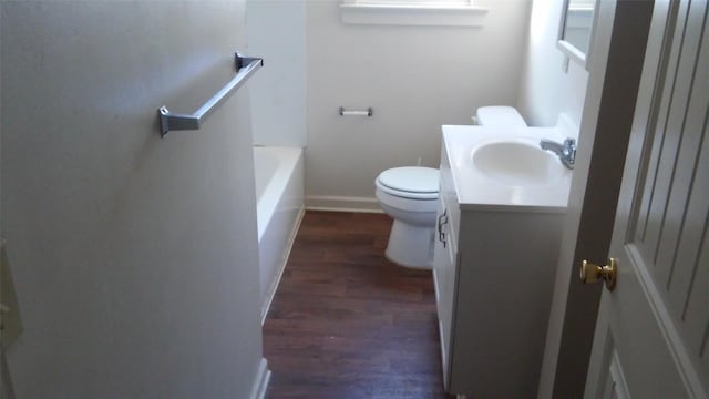 bathroom with toilet, vanity, a bathtub, and wood-type flooring