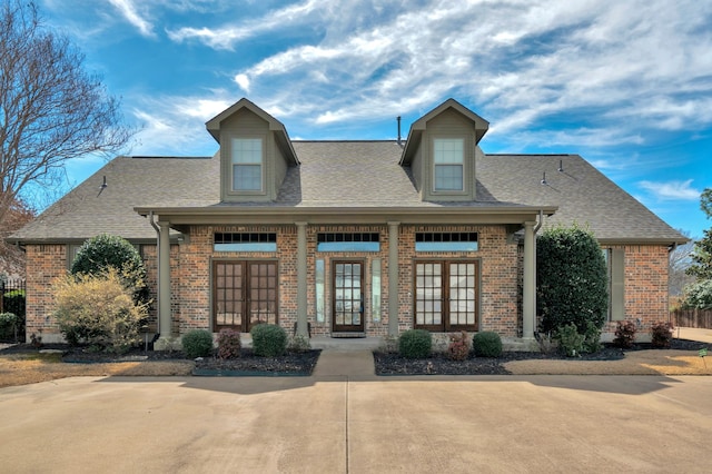 view of front of house featuring fence, a front lawn, concrete driveway, and french doors