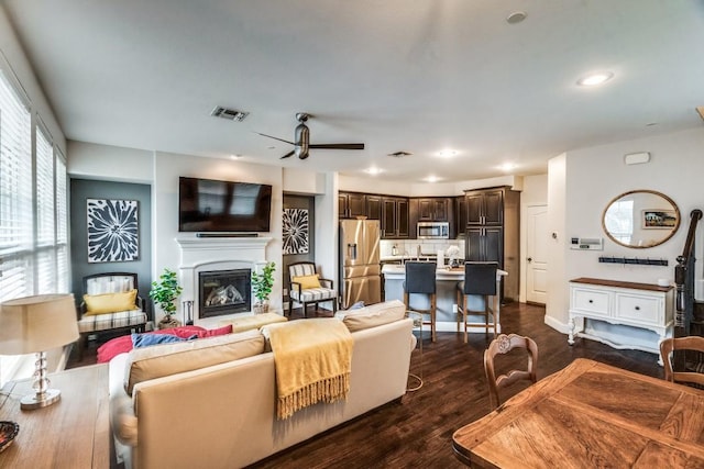 living room featuring ceiling fan and dark wood-type flooring