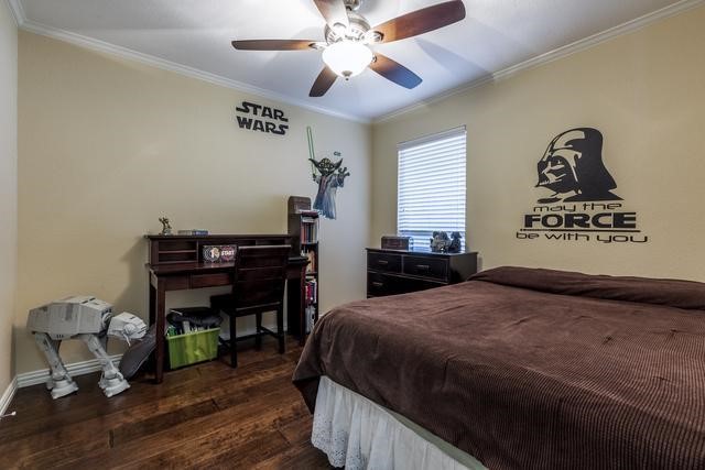 bedroom featuring ceiling fan, ornamental molding, and dark hardwood / wood-style floors