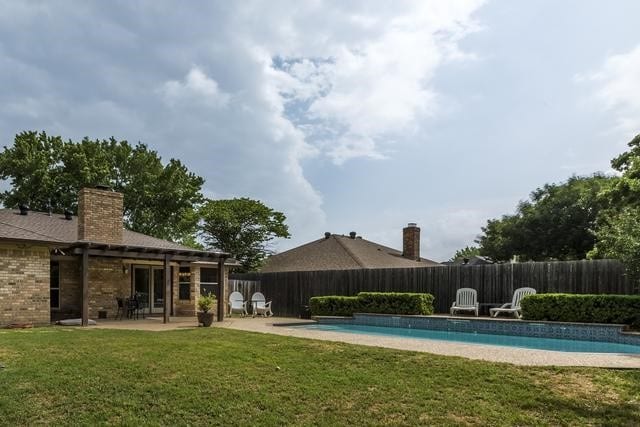 view of pool with a yard and a patio area