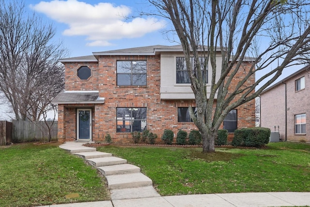 traditional home with a front yard, brick siding, and central air condition unit