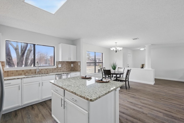 2160 Glenhaven Dr, Lewisville, TX 75067 - kitchen featuring dark wood finished floors, tasteful backsplash, a textured ceiling, white cabinetry, and light stone countertops