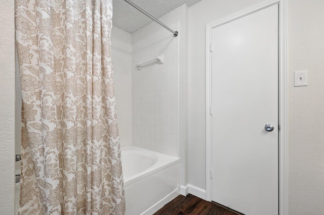 2160 Glenhaven Dr, Lewisville, TX 75067 - bathroom featuring a textured ceiling, wood finished floors, and shower / tub combo
