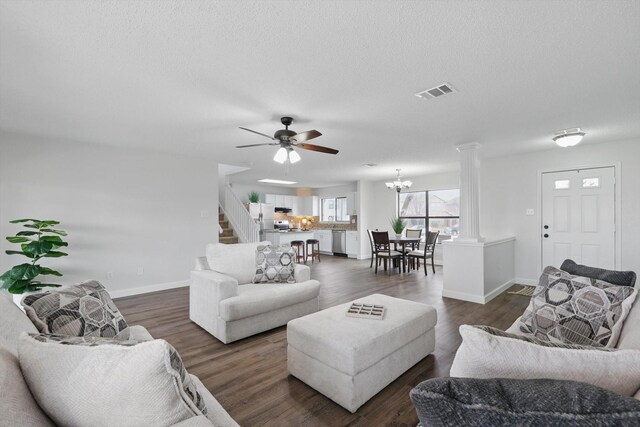 2160 Glenhaven Dr, Lewisville, TX 75067 - living area featuring decorative columns, stairway, ceiling fan, dark wood-style flooring, and a chandelier