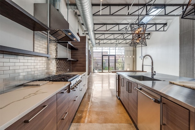 kitchen featuring sink, exhaust hood, stainless steel appliances, a high ceiling, and tasteful backsplash