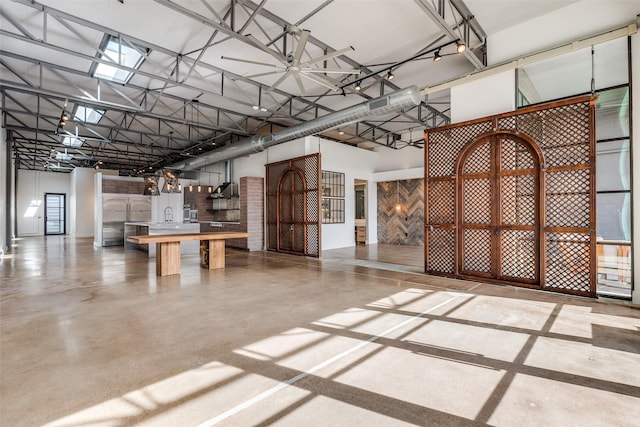 interior space featuring concrete flooring and a high ceiling